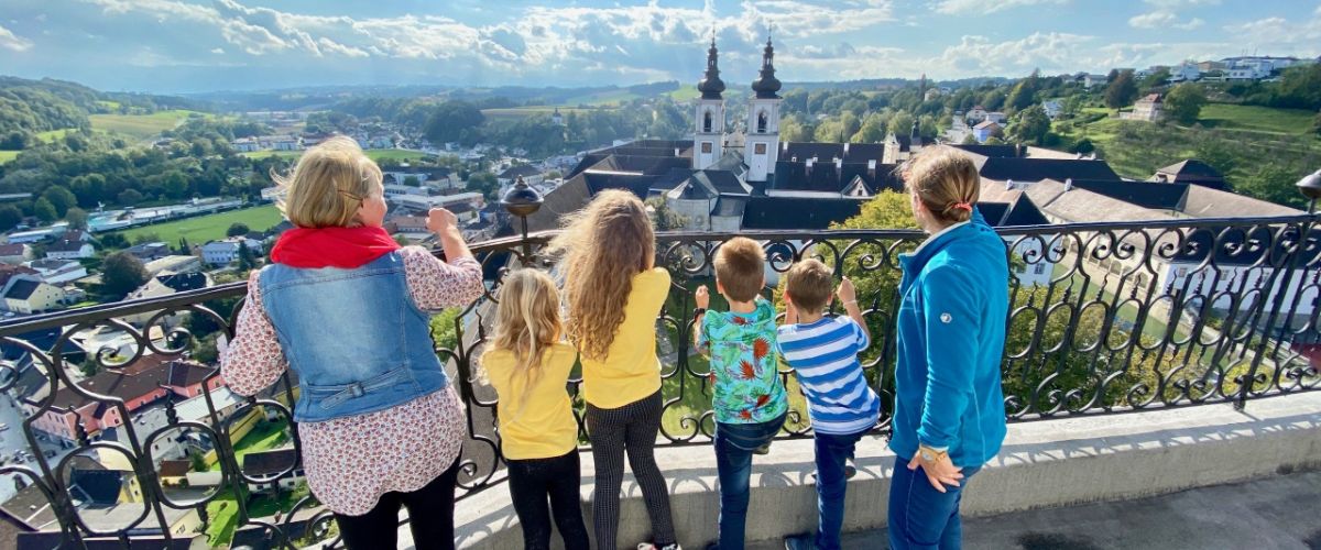 Stift Kremsmünster: Eine Führungsgruppe aus 4 Kindern und 2 Aufsichtspersonen blicken vom Dach der Sternwarte über die Stiftskirche in die weitläufige Hügellandschaft rundherum