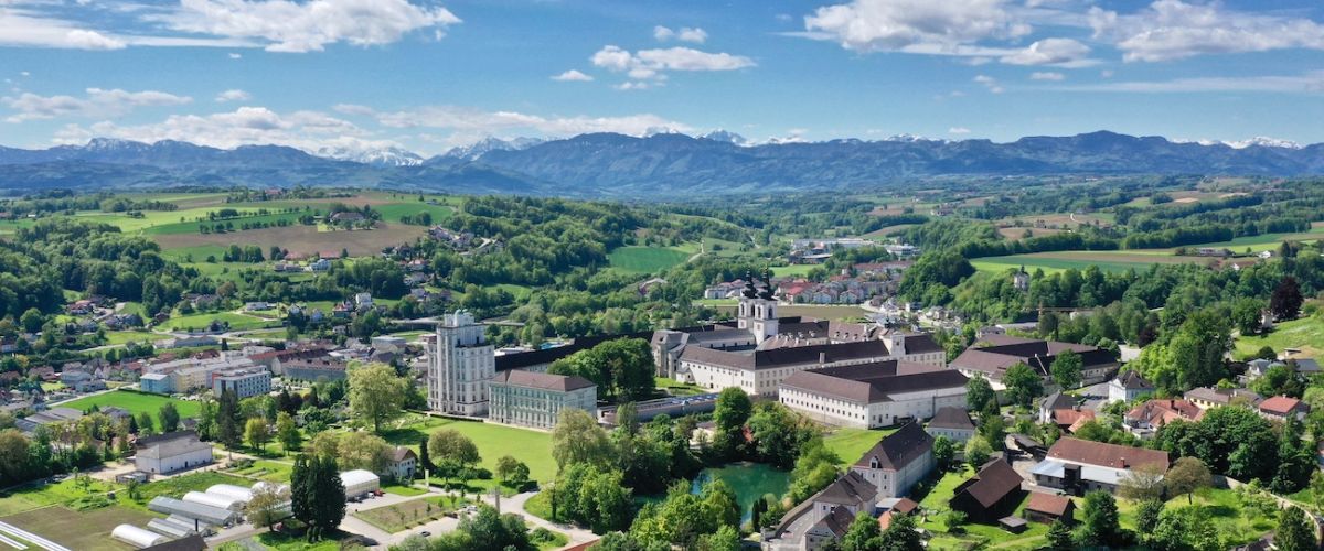 Frühling: Weitläufiger Blick um das Stift Kremsmünster bis in die schneebedeckten Alpen